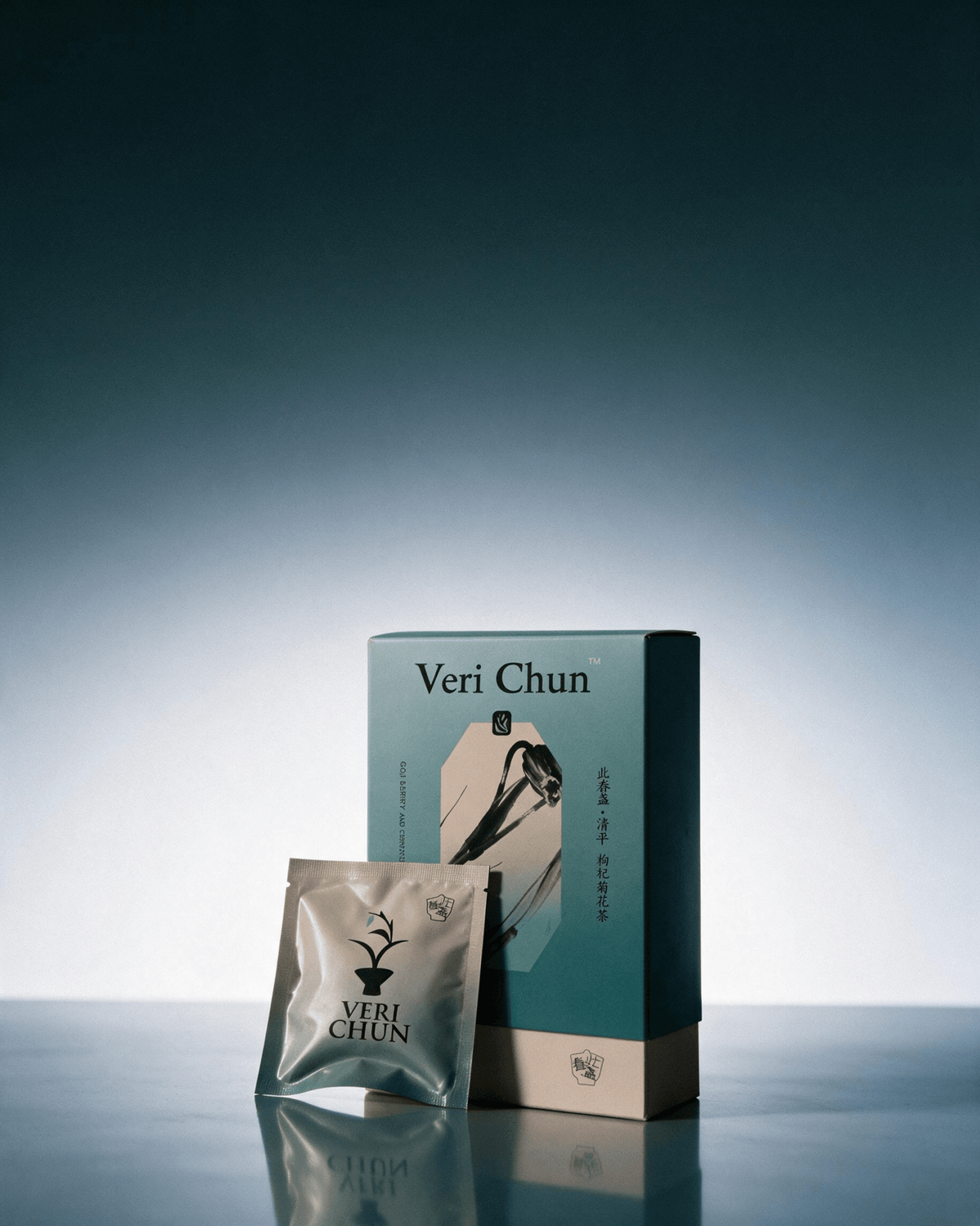 Qing Ping tea box and silver sachet on a reflective blue surface